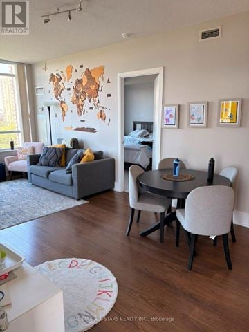 Toronto (Banbury-Don Mills) condo for rent - A living room with a grey couch, a black table and a world map on the wall.
