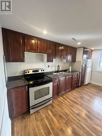 Pickering (Brock Ridge) apartment for rent - A kitchen with wooden cabinets and a black stove top oven.