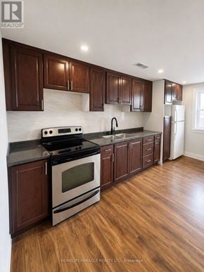 Pickering (Brock Ridge) apartment for rent - A kitchen with wooden cabinets and a black stove top.