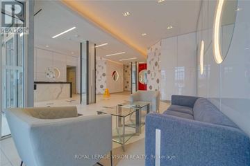 Toronto (Woburn) condo for rent - A modern living room with a glass table and grey and blue sofas.
