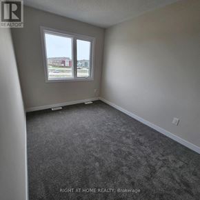 Ottawa townhouse for rent - A room with a carpeted floor and a window overlooking a parking lot.