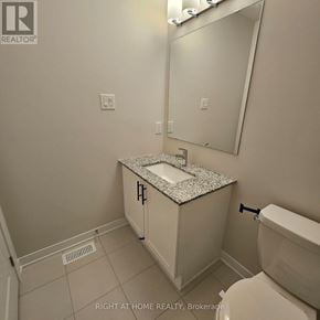 Ottawa townhouse for rent - A bathroom with a sink, toilet and mirror.
