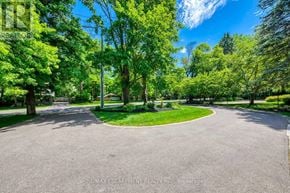 Oakville (Mo Morrison) apartment for rent - A tree-lined street curves around a grassy area.