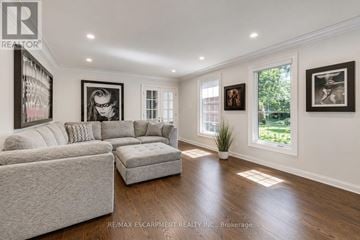 Oakville (Mo Morrison) apartment for rent - A living room with a grey couch and a white chair.
