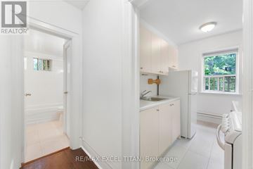 Toronto (High Park North) condo for rent - A white kitchen with a sink and a window.