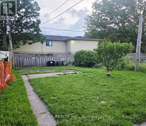 London East (East K) apartment for rent - A yard with a fence and a tree in front of a house.