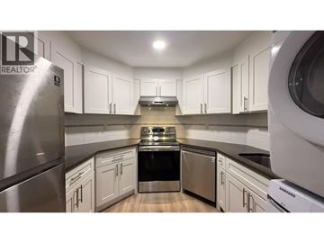 Port Moody apartment for rent - A modern kitchen with white cabinets and stainless steel appliances.