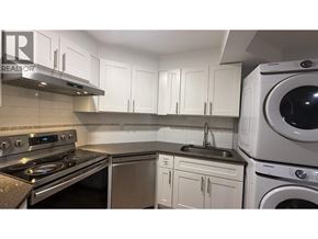 Port Moody apartment for rent - A modern kitchen with a stove, sink, and cabinets.