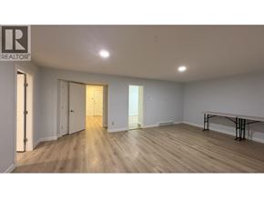Port Moody apartment for rent - A room with wooden floors and white walls, with a table and chairs in the corner.