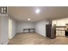 Port Moody apartment for rent - A kitchen area with a refrigerator, oven, and a dining table.