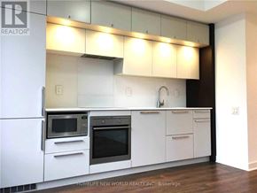 Toronto (Bay Street Corridor) condo for rent - A modern kitchen with white cabinets and stainless steel appliances.