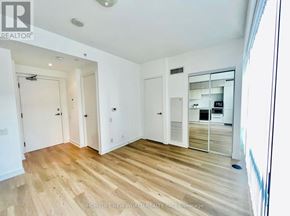 Toronto (Bay Street Corridor) condo for rent - A room with wooden flooring and white walls, with a door leading to another room visible in the background.