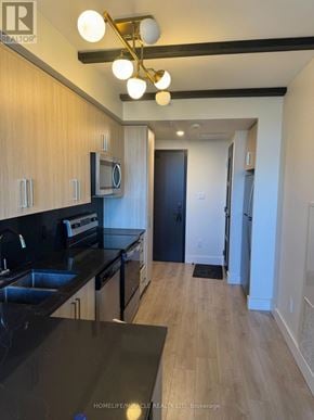 Waterloo condo for rent - A kitchen with wooden cabinets and black countertops.