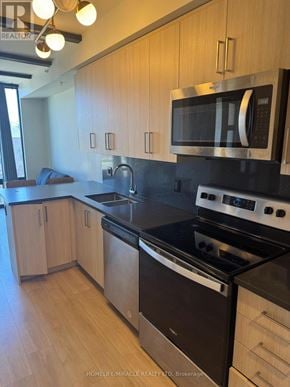 Waterloo condo for rent - A kitchen with wooden cabinets and black countertops.