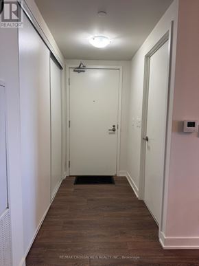 Toronto (Flemingdon Park) condo for rent - A hallway with a door at the end and a brokerage logo on the wall.