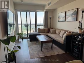 Toronto (Flemingdon Park) condo for rent - A living room with a large window and a view of the city.
