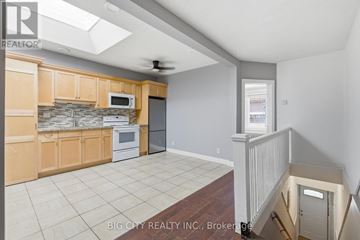 Toronto (Wychwood) apartment for rent - A kitchen with wooden cabinets and a tiled backsplash.