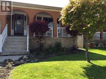 Toronto (L'amoreaux) apartment for rent - A house with a front porch and a tree in front.