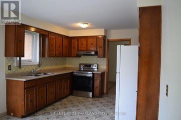 Toronto (L'amoreaux) apartment for rent - A kitchen with wooden cabinets and a white refrigerator.