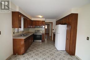 Toronto (L'amoreaux) apartment for rent - A kitchen with wooden cabinets and a patterned floor.