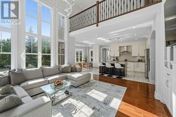 Vaughan (Maple) apartment for rent - A spacious living room with a glass coffee table and a staircase.