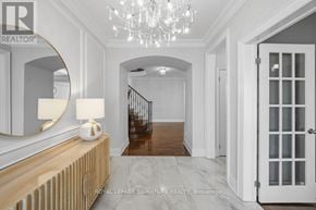 Vaughan (Maple) apartment for rent - A well-lit hallway with a chandelier, a mirror, and a wooden bench.