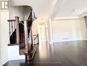 Newmarket (Stonehaven-Wyndham) apartment for rent - A spacious room with a wooden staircase and hardwood floors.