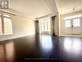 Newmarket (Stonehaven-Wyndham) apartment for rent - A spacious room with wooden floors and white walls.