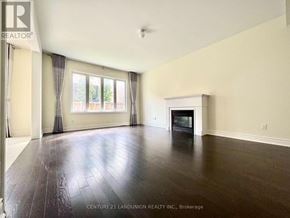Newmarket (Stonehaven-Wyndham) apartment for rent - A spacious room with a fireplace and wood flooring.