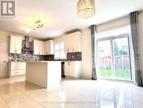 Newmarket (Stonehaven-Wyndham) apartment for rent - A well-lit kitchen with a stone backsplash and white cabinets.