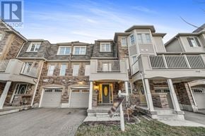 Milton (Wi Willmott) townhouse for rent - A large, multi-story residential building with a central entrance and garage doors.