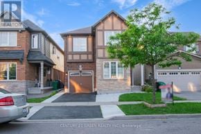 Brampton (Northwest Brampton) apartment for rent - A house with a car parked in front and a tree to the right.