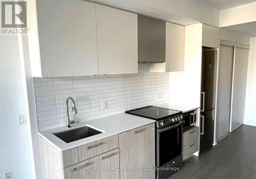 Toronto (Church-Yonge Corridor) condo for rent - A kitchen with white cabinets and a black stove top oven.