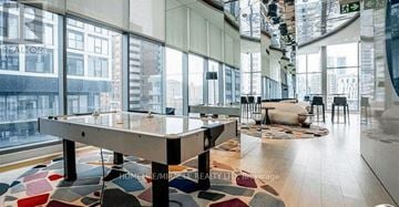 Toronto (Church-Yonge Corridor) condo for rent - A bright, modern living room with a large table and a view of the city.