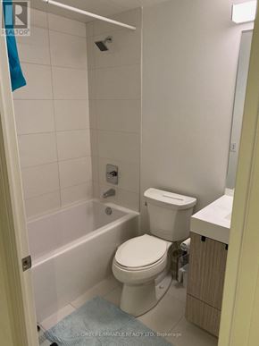 Toronto (Church-Yonge Corridor) condo for rent - A white toilet in a small bathroom with a blue rug on the floor.