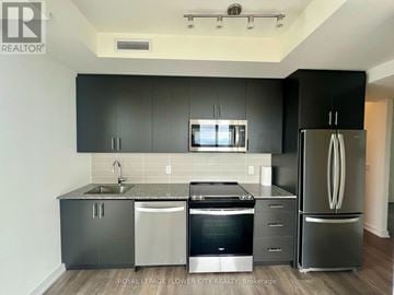 Oakville (Jm Joshua Meadows) condo for rent - A kitchen with black cabinets and stainless steel appliances.
