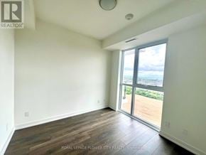 Oakville (Jm Joshua Meadows) condo for rent - A room with a view of a parking lot through a sliding glass door.
