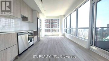 Toronto (North St. James Town) condo for rent - A kitchen with a stainless steel refrigerator and wooden floors.
