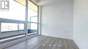 Toronto (North St. James Town) condo for rent - A room with a sliding glass door and wooden flooring.