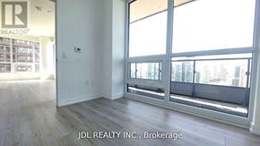 Toronto (North St. James Town) condo for rent - A room with a view of the city through large windows.
