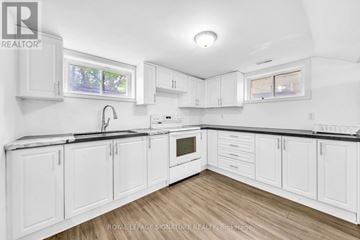 Newmarket (Central Newmarket) apartment for rent - A white kitchen with wooden floors and white cabinets.