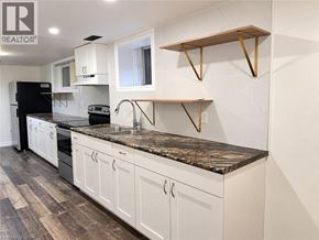 Kitchener apartment for rent - A kitchen with white cabinets and a black refrigerator.