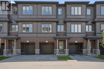 Cambridge townhouse for rent - A large, multi-story residential building with a brick facade and multiple garage doors.