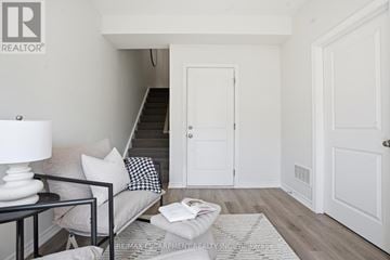Cambridge townhouse for rent - A living room with a couch, a lamp, a coffee table and a staircase.