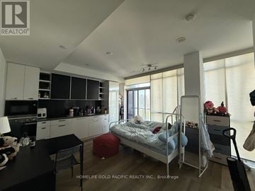 Toronto (Annex) condo for rent - A bedroom with a bed, chair, and a table with a lamp on it.