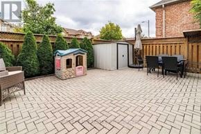 Vaughan (Maple) apartment for rent - A backyard with a patio, a small house, and a table with chairs.