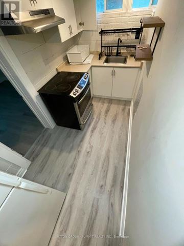Markham (Markham Village) apartment for rent - A kitchen with a black stove top oven and white cabinets.