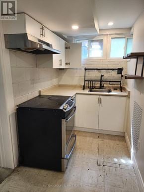 Markham (Markham Village) apartment for rent - A kitchen with a black fridge and white cabinets is for sale.
