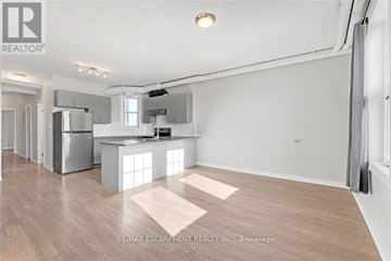 Hamilton (Gibson) apartment for rent - A spacious kitchen with white cabinets and a wooden floor.