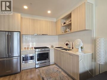 Coquitlam apartment for rent - A modern kitchen with wooden cabinets and stainless steel appliances.